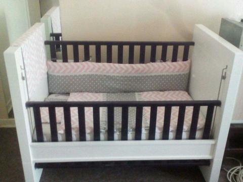 Neat solod baby cot with bedding