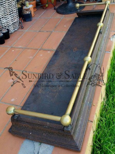 Vintage original fireplace surround with decorative brass railing and cast iron base