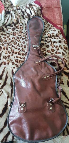 Brown leather guitar bag with red velvet inside