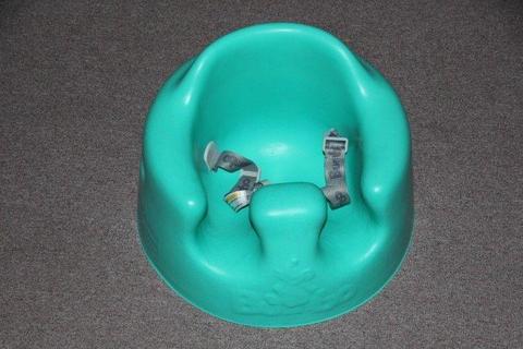 Green/blue baby Bumbo chair with straps
