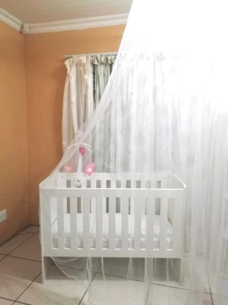 Adjustable wooden cot with accessories