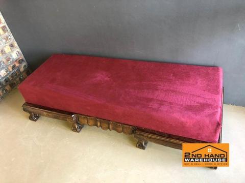 Large wooden ottoman with red cushion seating