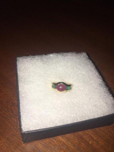 Gold ladies ring with garnet and four small emeralds