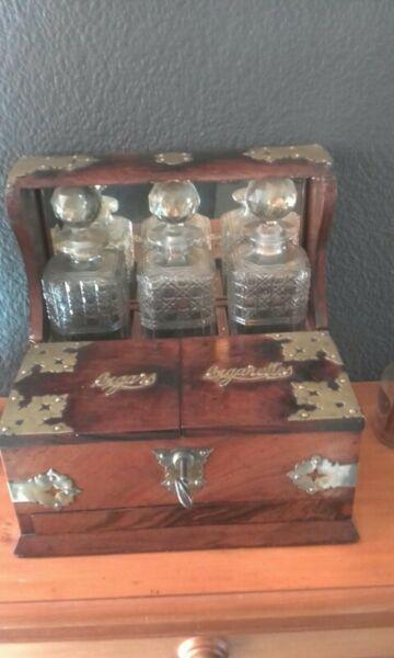 Antique English oak Tantalus, 3 crystal decanters 