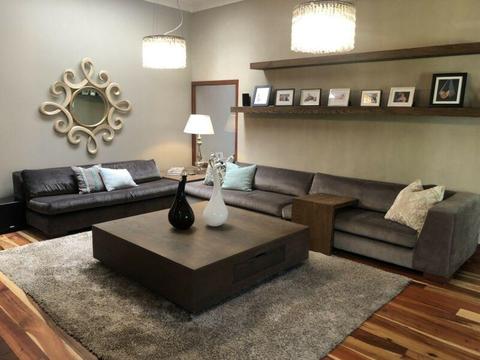 Modern grey L-shaped couch with corner table  